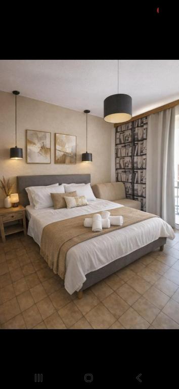 a bedroom with a large bed with two towels on it at Art Studios Benitses in Benitses