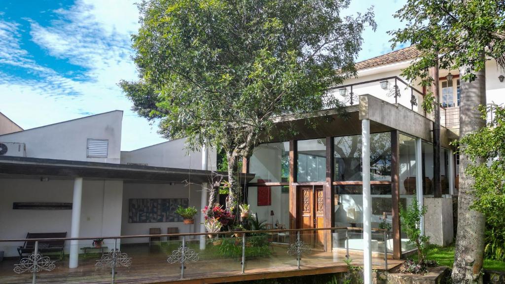 a house with glass doors and a tree at Oratório Pousada Boutique in Tiradentes
