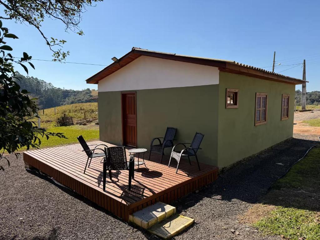 a small green house with chairs on a deck at Cabanas Belvedere in Lauro Müller