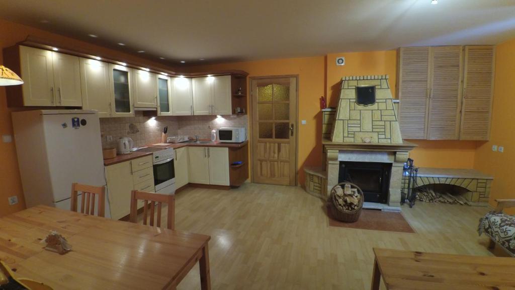 uma cozinha e sala de jantar com uma mesa e uma lareira em Dom W Rzepiskach em Rzepiska