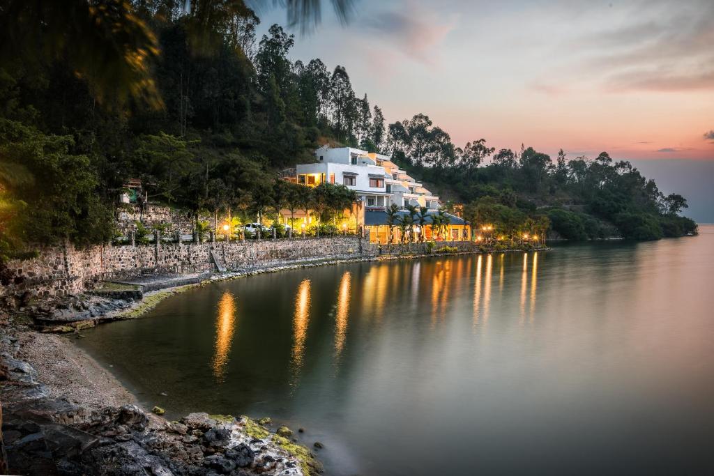a view of a river with buildings on the shore at Moriah Hill Resort in Kibuye