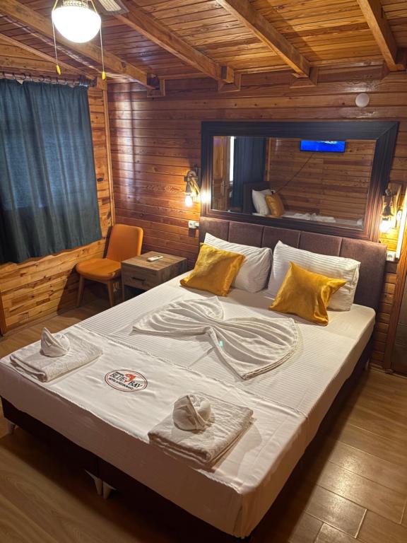 a bedroom with a large bed with towels on it at Adrasan blue bay hotel in Kumluca