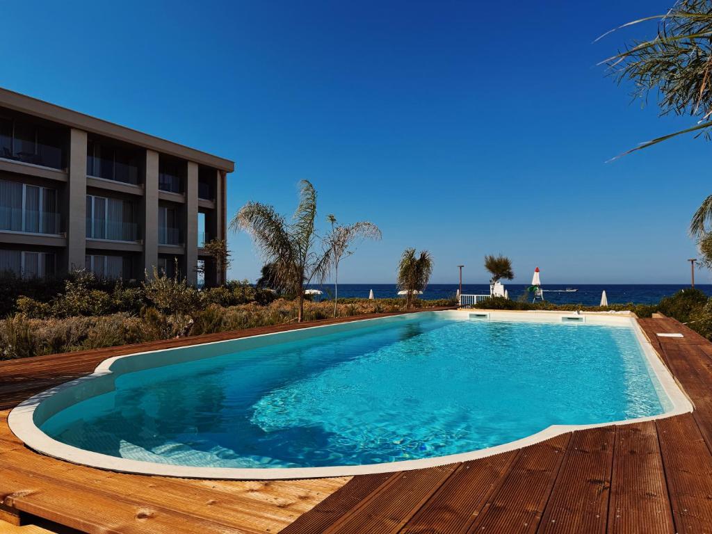 a swimming pool on a wooden deck next to a building at Metamare in Cozze