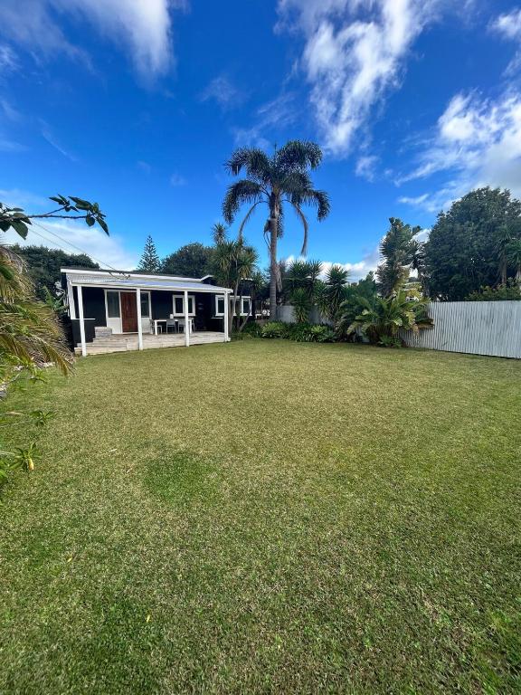 a house with a yard with a palm tree at Oneroa Manuka Residence in Waiheke Island