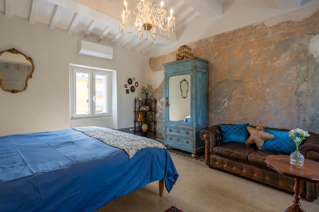 a bedroom with a blue bed and a couch at casa stella a due passi dal centro in Arezzo