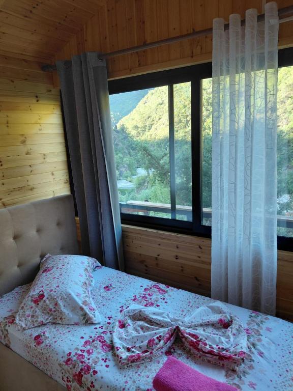 a bed in a room with a large window at Krahina e Shllakut in Koman