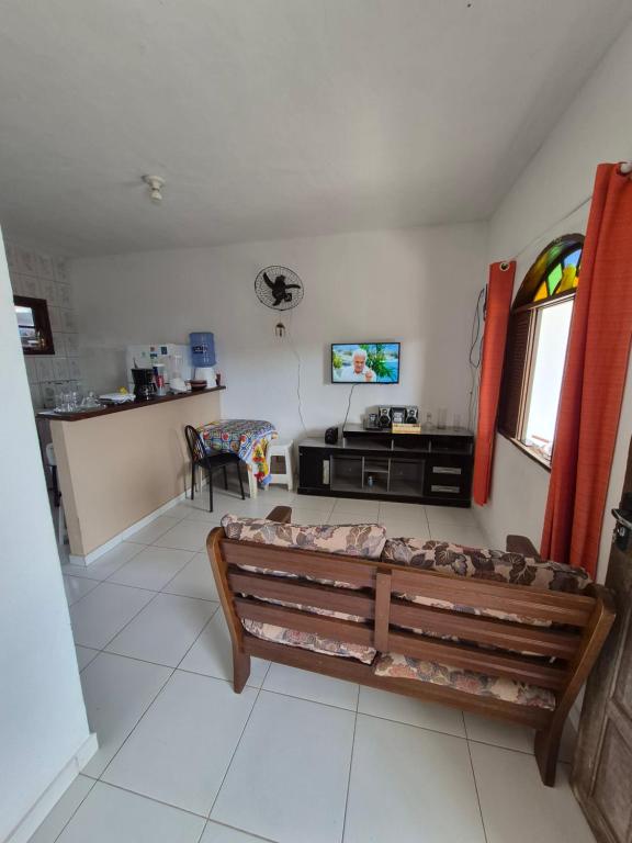 a living room with a bench and a tv at Nataliana's House in Cabo Frio