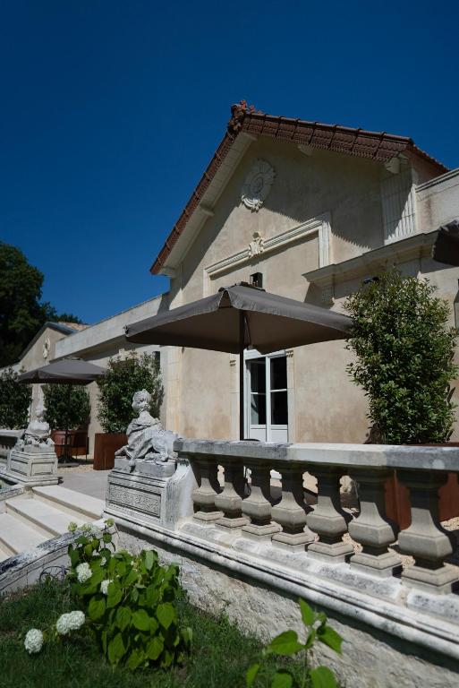 a house with an umbrella in front of it at Logis de l'Héronière in Salles-sur-Mer