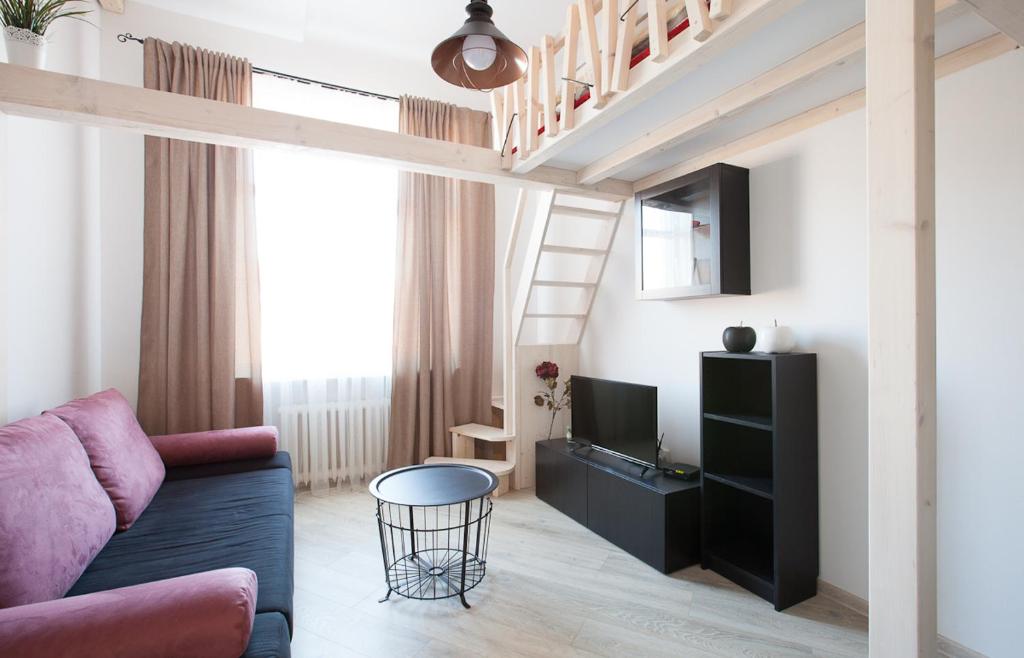 a living room with a couch and a loft bed at Giedres Old Town Apartments in Kaunas