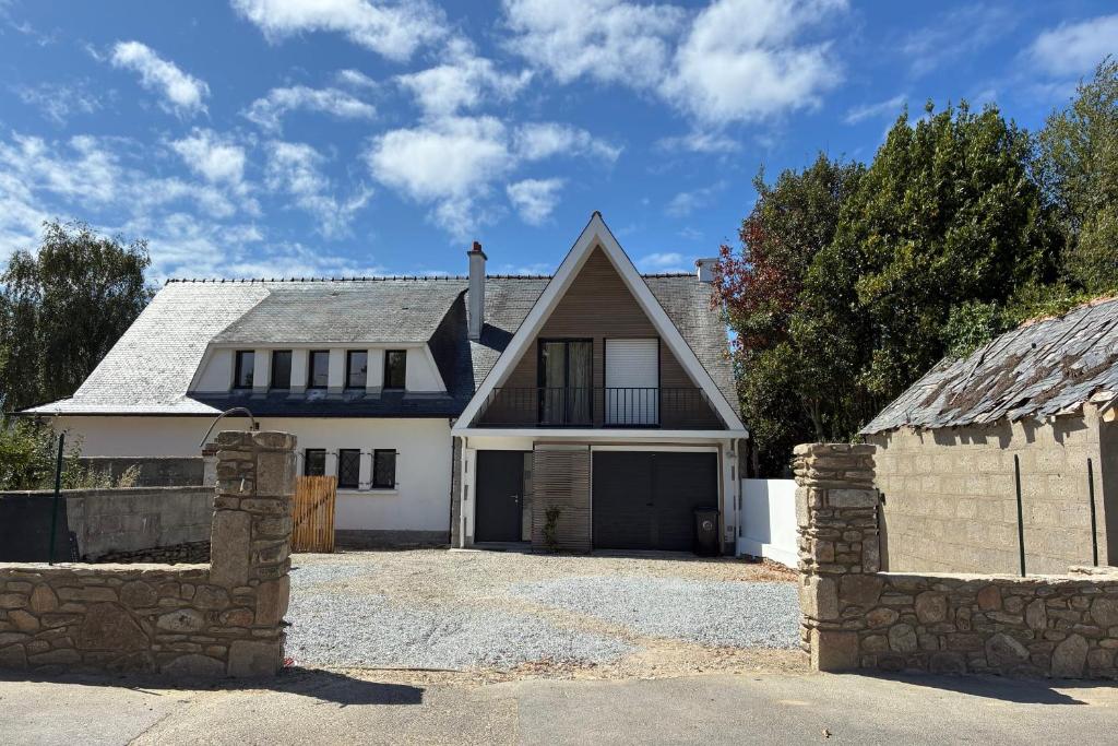 a large white house with a stone wall at Maison proche grande plage in Quiberon