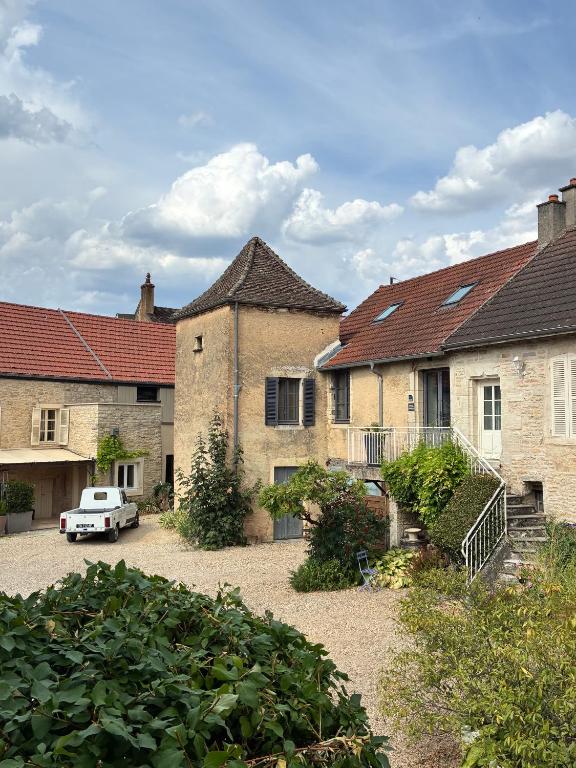 a group of buildings with a car parked in a courtyard at La Parenthèse Bourguignonne in Savigny-lès-Beaune