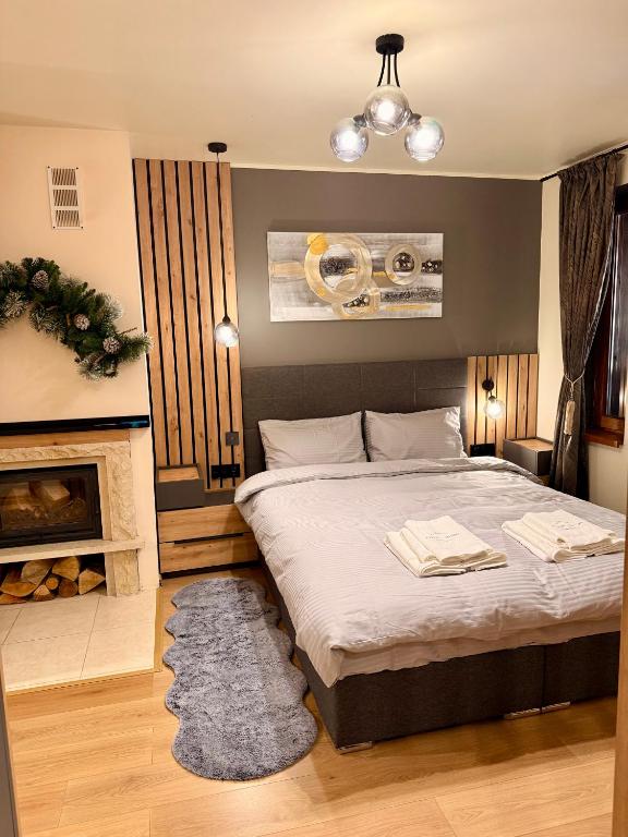 a bedroom with a large bed and a fireplace at Avelov Studio Pamporovo in Pamporovo
