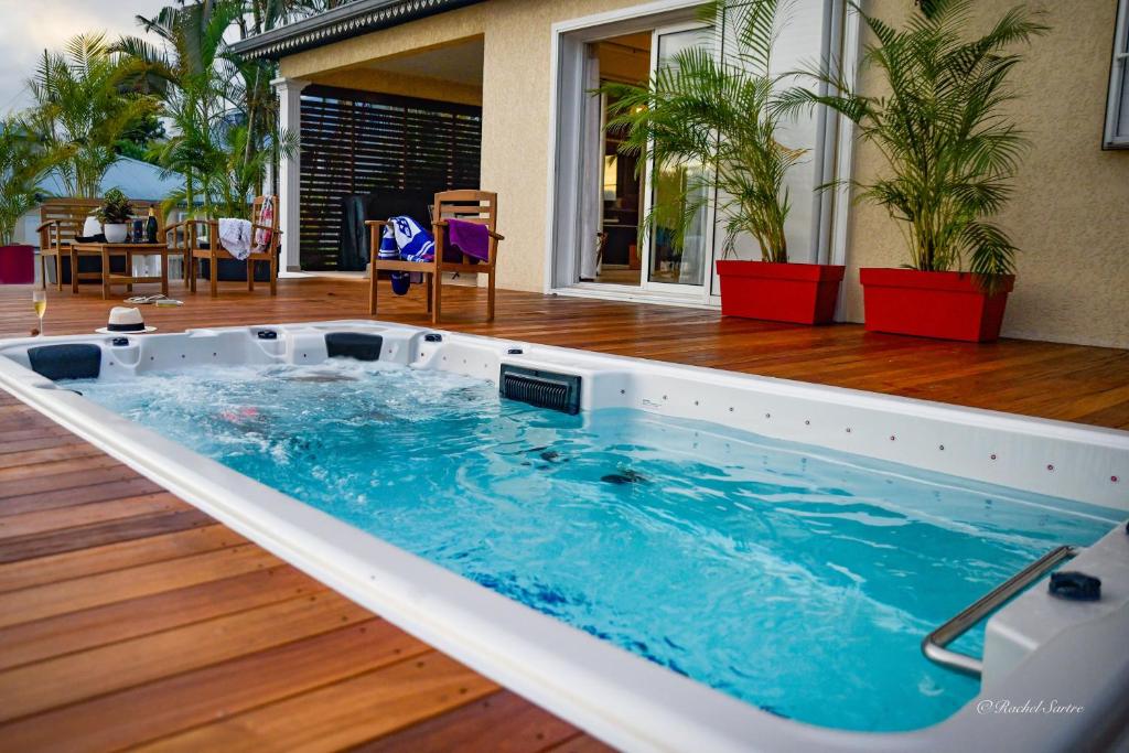 a hot tub in the middle of a deck at Ty Lodge Réunion, Piscine, Spa, Vue Océan, Jardin, entre Saint-Pierre et volcan in Le Tampon