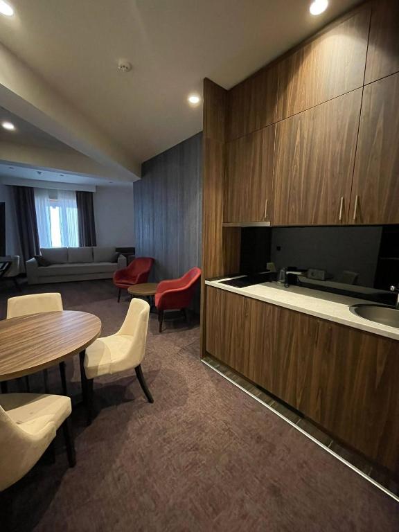 a room with a table and chairs and a kitchen at LUNAS Apartmani 7 in Kopaonik