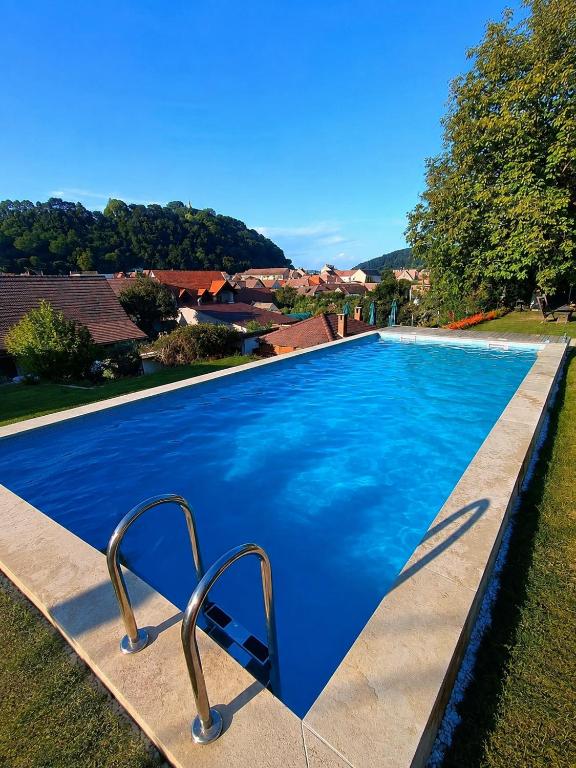 a swimming pool with blue water in a yard at Casa Adalmo in Sighişoara