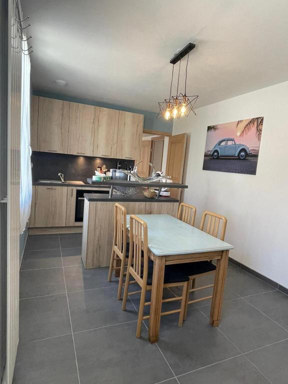 a kitchen with a table and chairs in a kitchen at La Maison Belle in Germigny