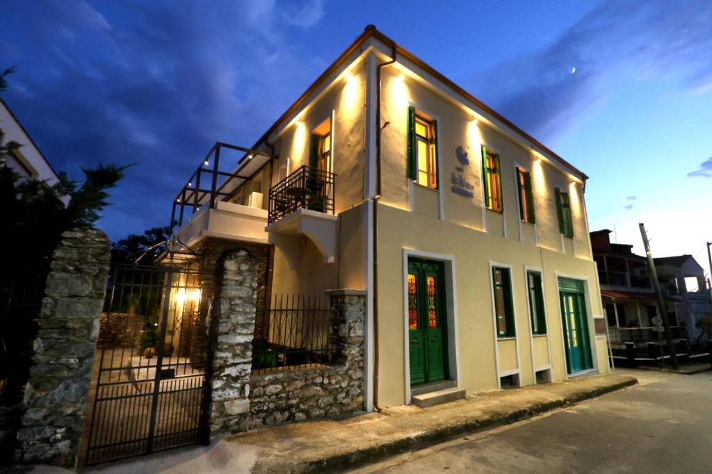 a white house with lights on the side of it at Ξενώνας Λελέκι in Ayiá