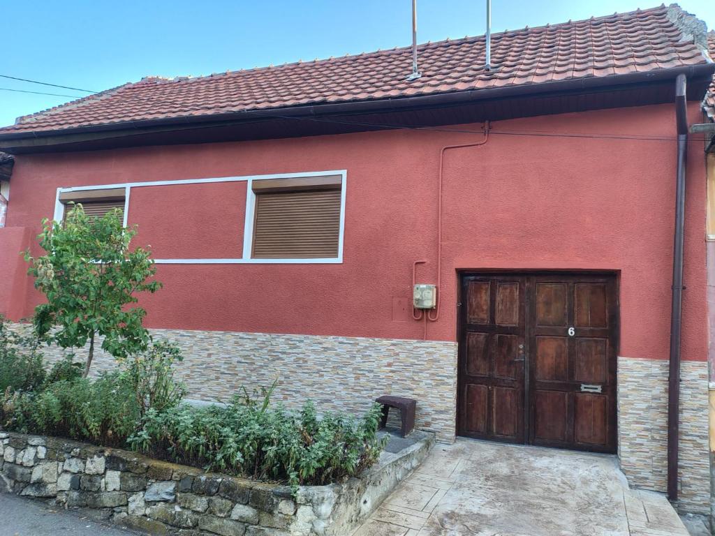 a red brick house with a wooden door at Casa La Bunica in Orşova