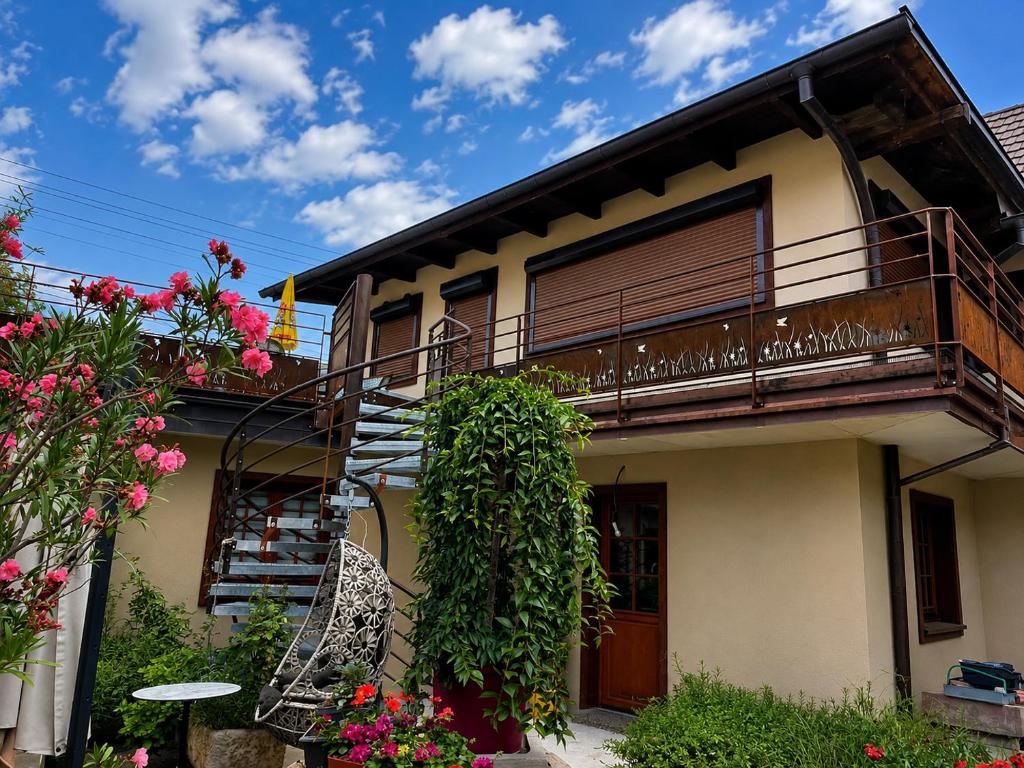 a house with a balcony and flowers at Duplex rénové avec terrasse privative à 10 mm de Colmar et Eguisheim, à 2 mm du grand axe autoroutier Strasbourg Mulhouse in Sainte-Croix-en-Plaine