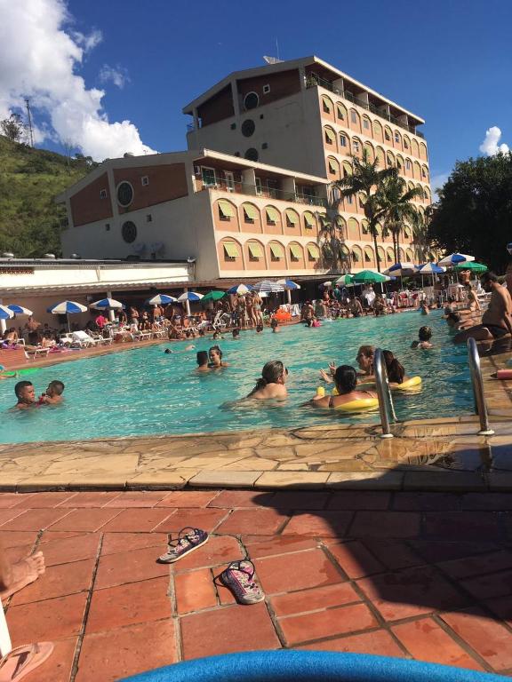 a group of people in a swimming pool at a hotel at Apartamento Hotel Cavalinho Branco in Águas de Lindoia