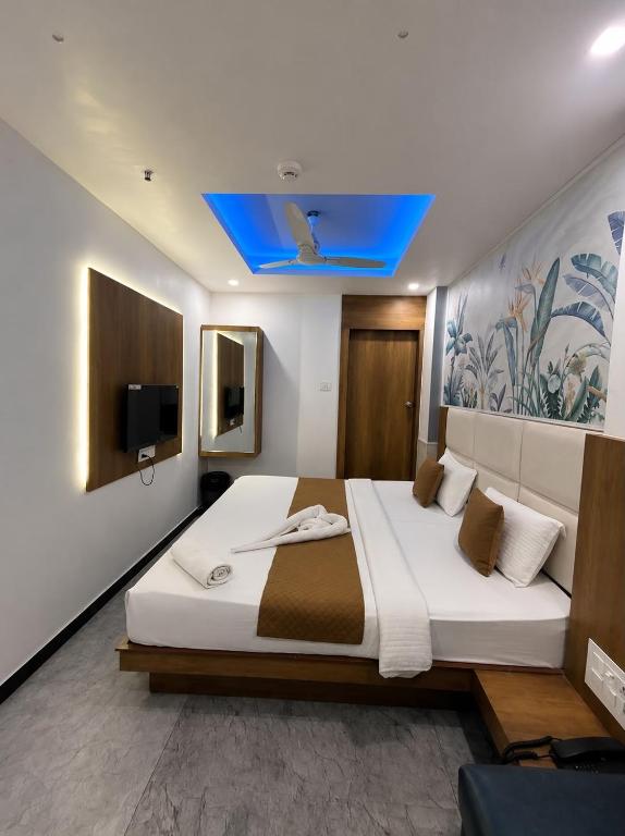 a bedroom with a large bed with a blue ceiling at Hotel secure inn kadodara road in Surat