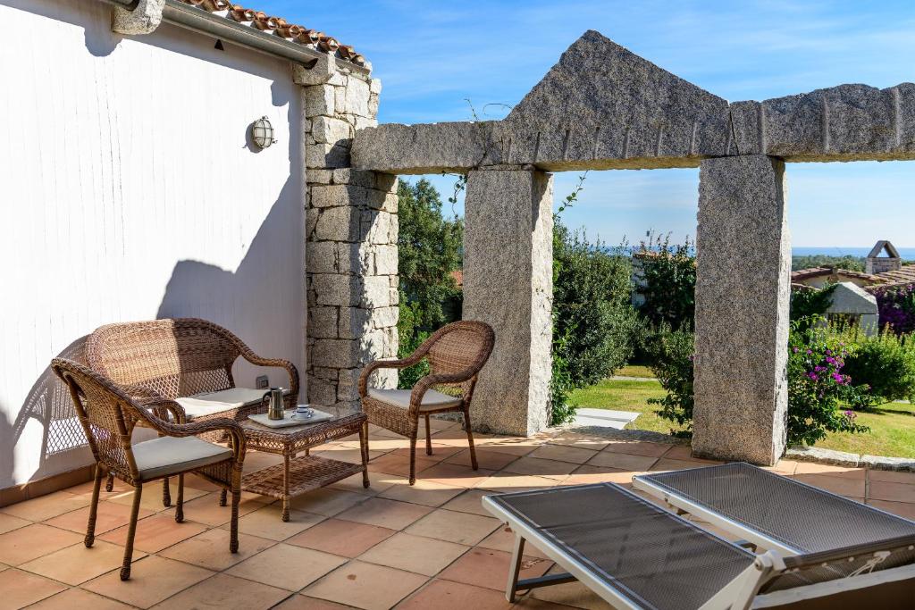 a patio with two chairs and a table and a table at Li Conchi 34 in Castiadas