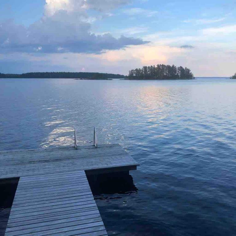 a dock in the middle of a large body of water at Saimaanranta mökki in Kokkoniemi