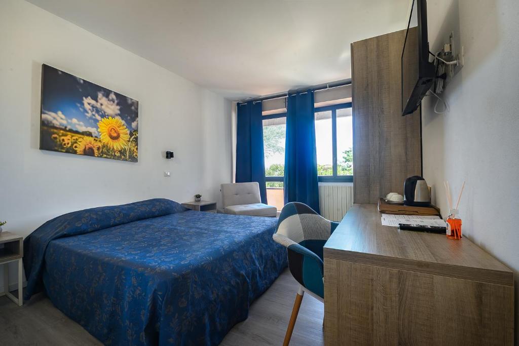 a bedroom with a blue bed and a desk with a desk at Hotel Anna in Siena