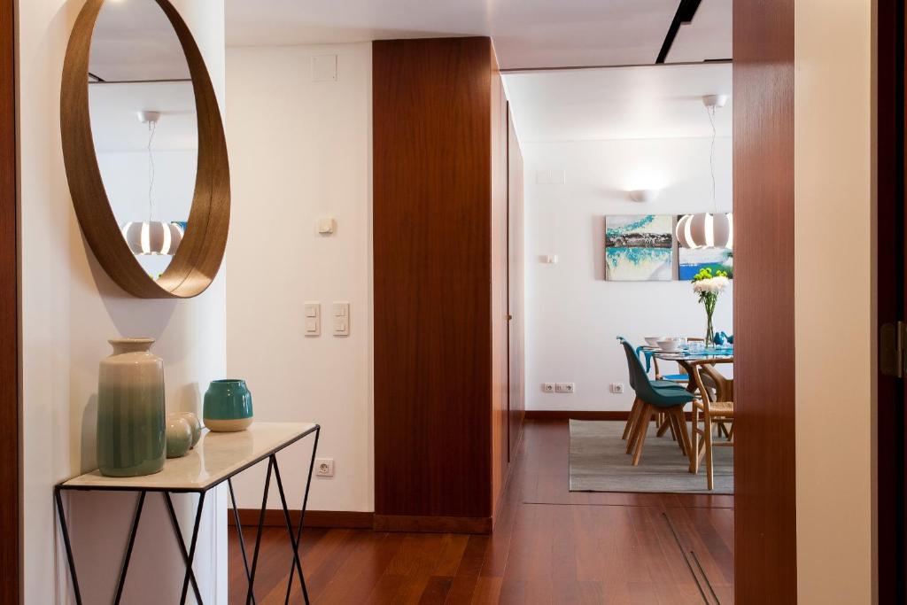 uma sala de estar com uma mesa e um espelho em Charming 2-Bedroom Apartment in the City Centre em Lisboa
