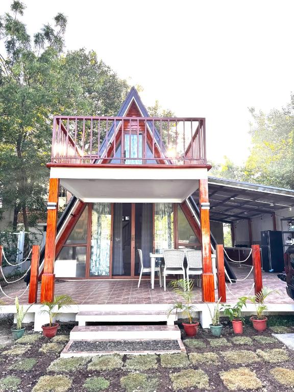a house with a deck with a table and chairs at Balay @ Santa Fe, Bantayan in Pooc