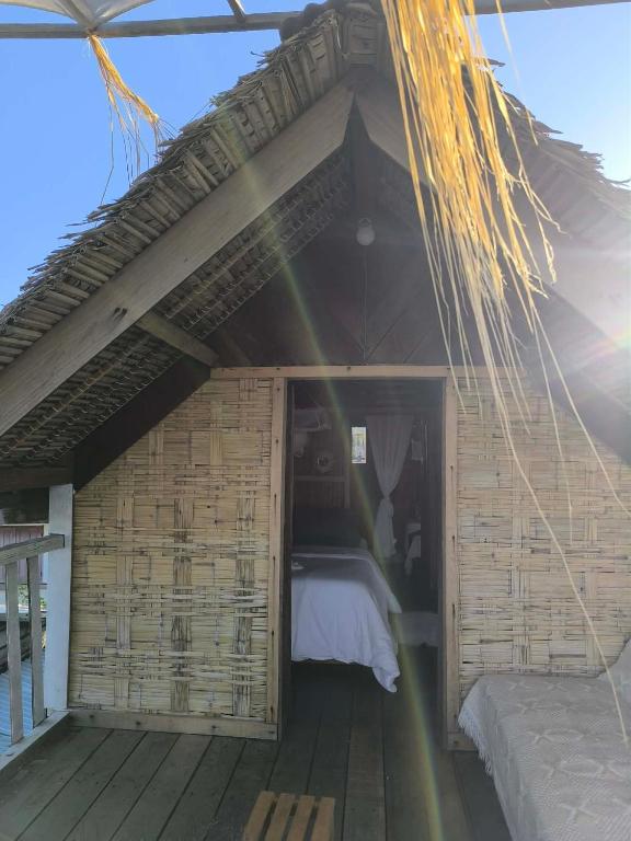 a room with a bed in a wooden house at Erina Beach in Antalaha
