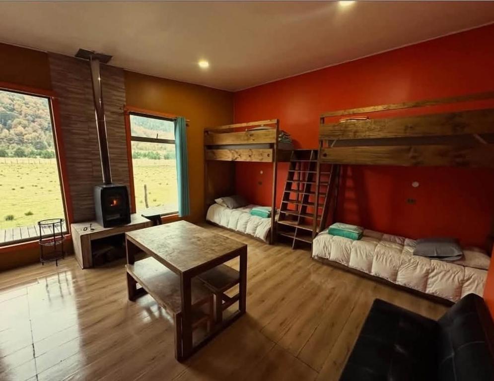a room with two bunk beds and a table at La Alea Malalcahuello in Malalcahuello