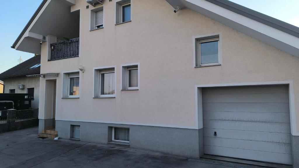 a large white house with a garage door at Apartment Maria Domžale in Domžale
