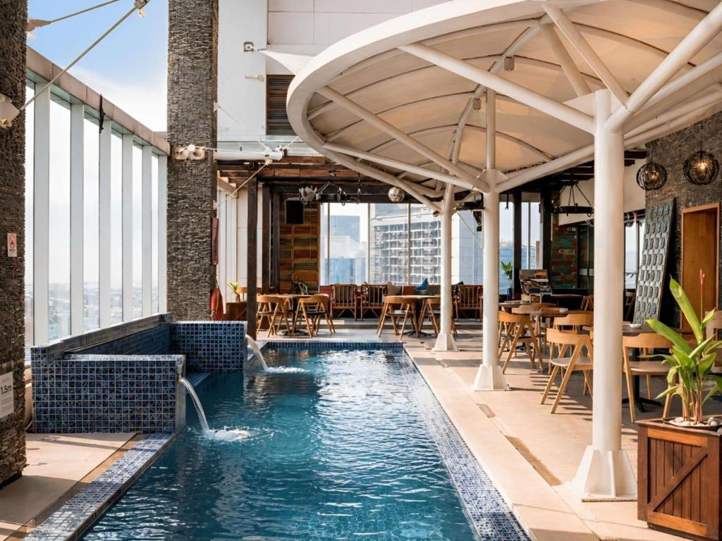 an indoor pool with tables and chairs on a building at Mercure Jakarta Simatupang in Jakarta