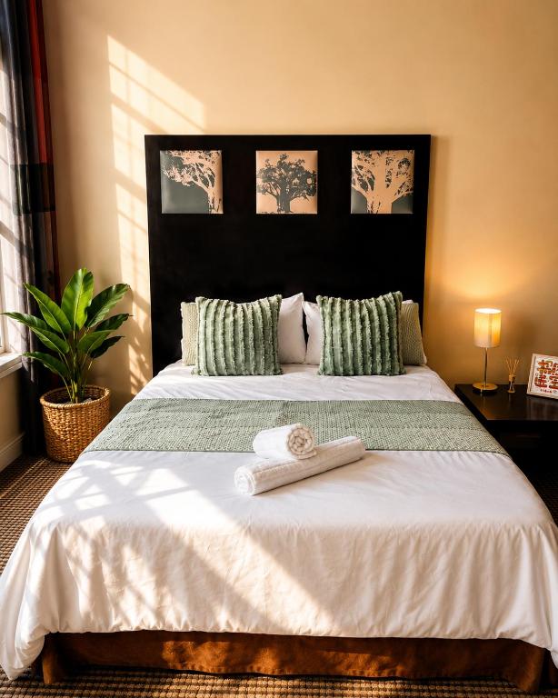 a bedroom with a large bed with two towels on it at iNtsika Boutique in Johannesburg
