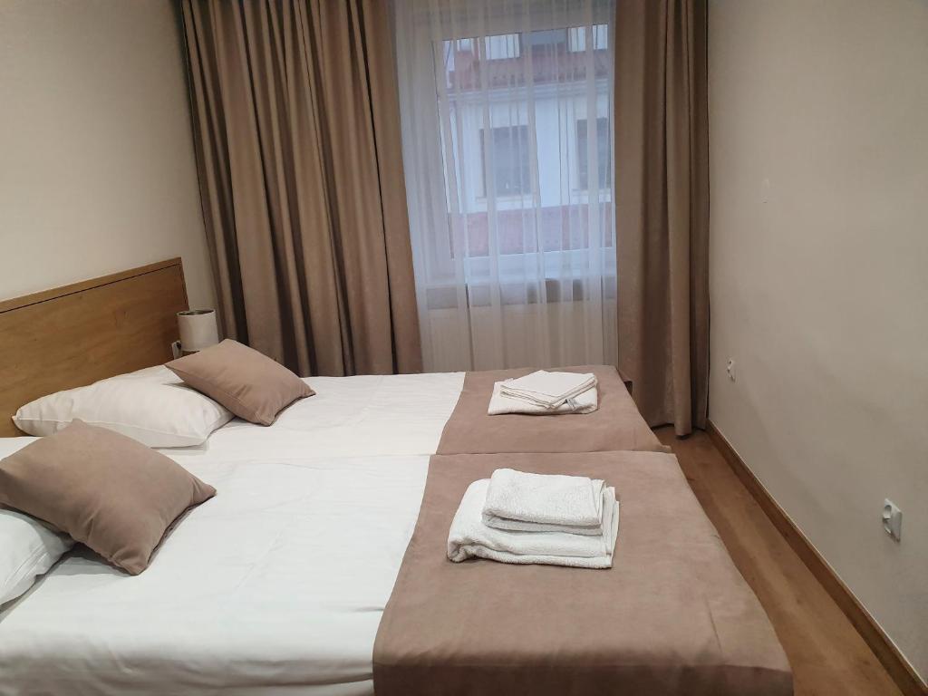 a hotel room with two beds with towels on them at Pokoje gościnne vis a vis Retro in Gostynin