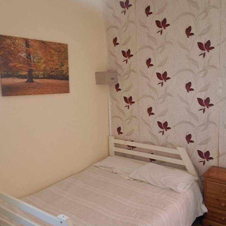a bedroom with a bed and a wall with butterflies at New Hawkes Hotel in Blackpool