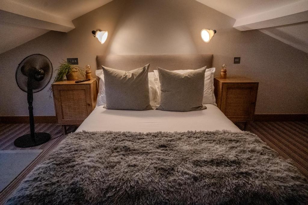 a bedroom with a bed with white sheets and pillows at The Vineyard Lamberhurst in Lamberhurst