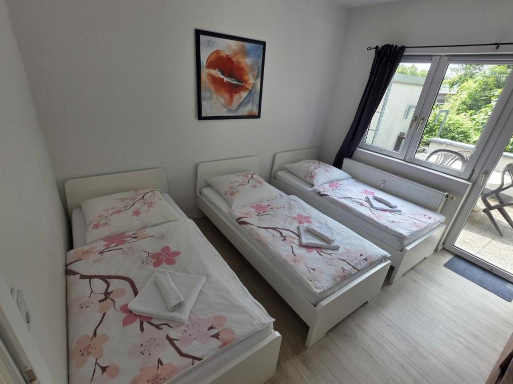 two twin beds in a room with a window at Ferdimesse Apartments in Cologne