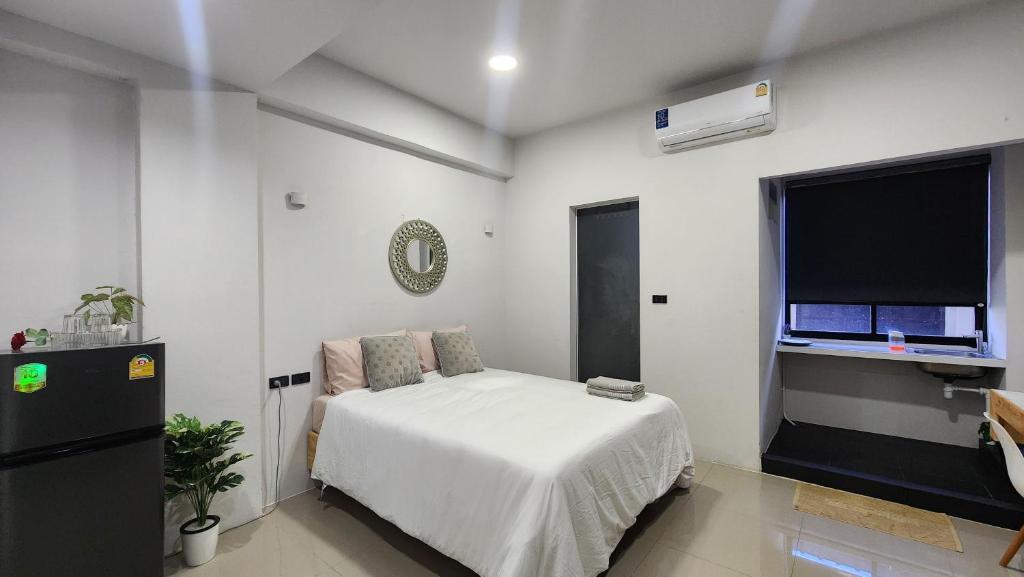 a white bedroom with a bed and a window at Irich residence South Samrong 6 Kms BTS-Pu Chao in Samut Prakan