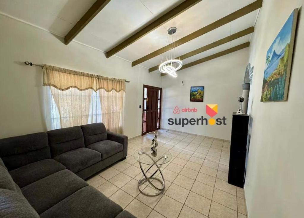 a living room with a couch and a sign on the wall at Exclusive Casa Oro 3VX in San Pedro Sula
