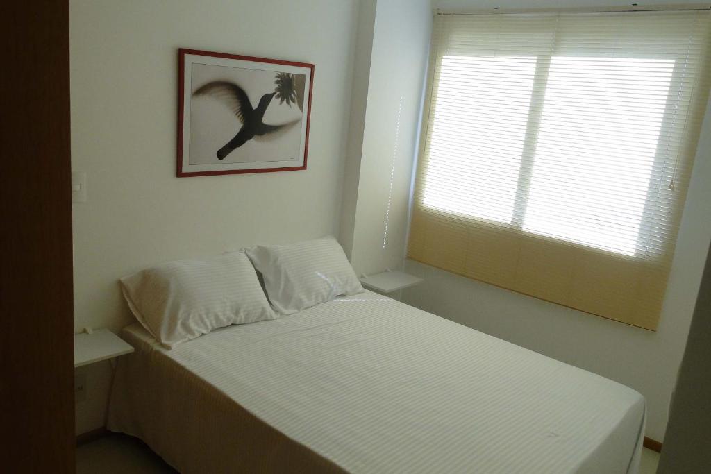 1 dormitorio con 1 cama y una foto de un pájaro en Apartamento Completo no Jardim da Barra - Barra Olímpica, en Río de Janeiro