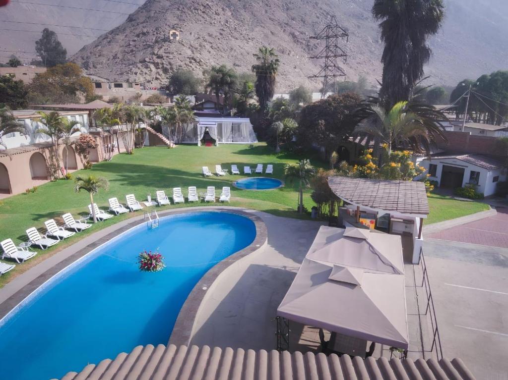 an overhead view of a swimming pool with chairs and a mountain at El Angolo Chosica in Nicolas de Pierola