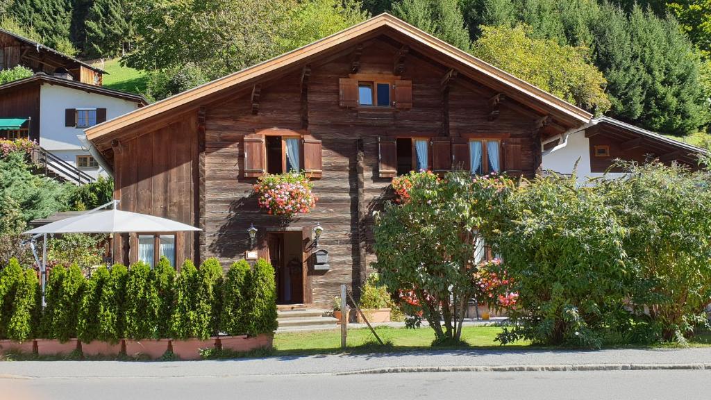 a wooden house with flowers in front of it at Montafonerhaus in Schruns