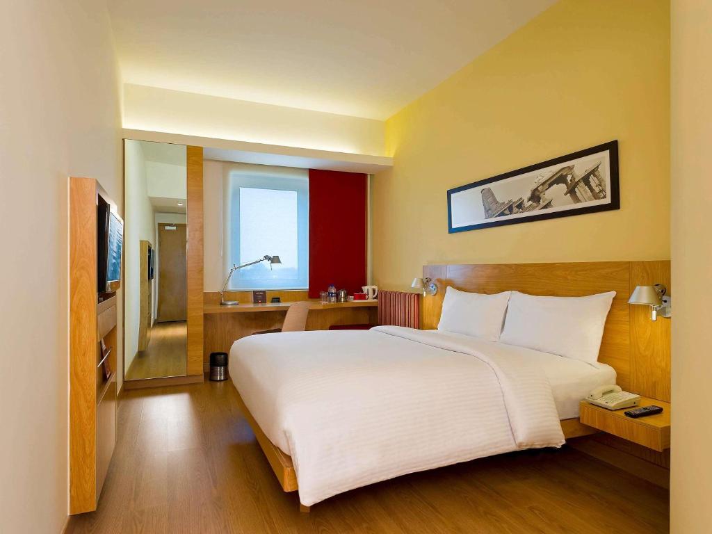 a large white bed in a hotel room at ibis Nashik - An Accor Brand in Nashik