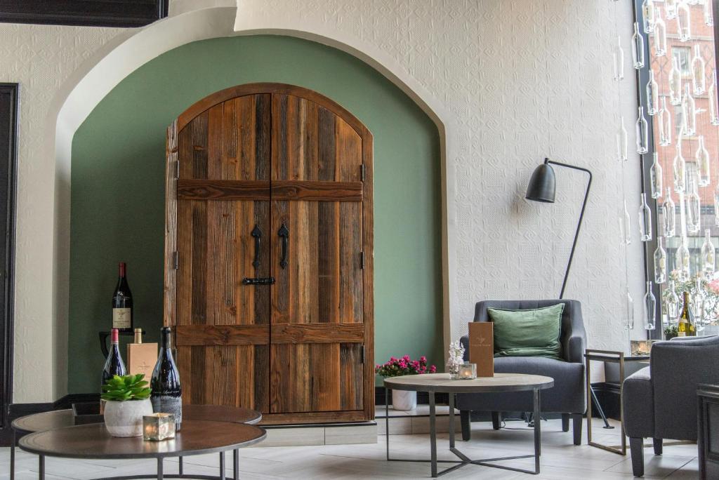 a large wooden door in a room with chairs and tables at Hotel Lucia in Portland