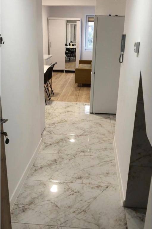a room with a hallway with a marble floor and a door at Polna 16 in Mrągowo