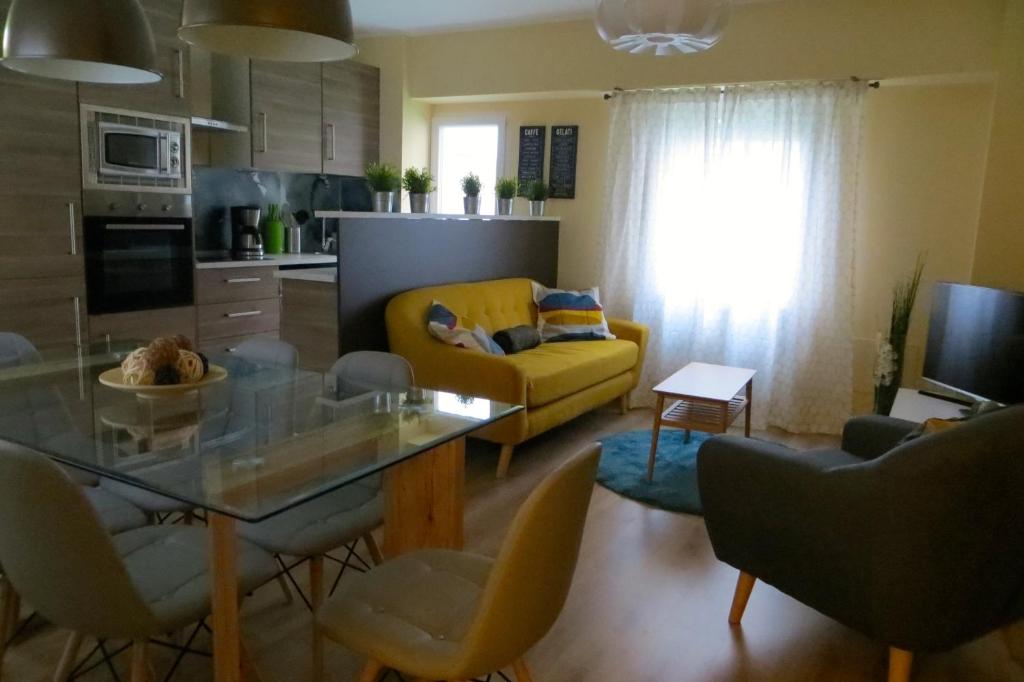 a living room with a yellow couch and a glass table at Viv. Turística Museo del Comercio in Salamanca