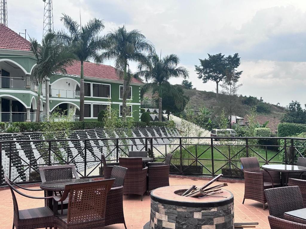 a patio with chairs and tables and a house at El Gado Casas in Kampala