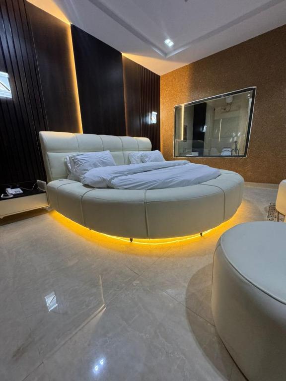 a bedroom with a large bed in a room with a tv at One One B Luxury Hotel in Asaba